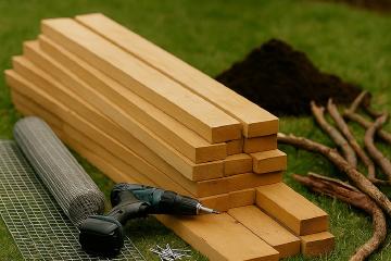Selbstgebautes Hochbeet aus Holz im Garten mit bepflanzter Oberfläche